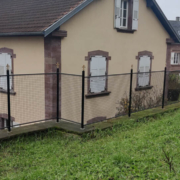 Pose d’une clôture en fer forgé sur un mur en grès à Oberbronn