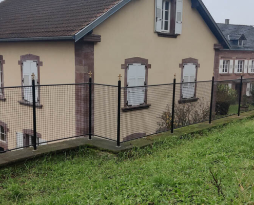 Pose d’une clôture en fer forgé sur un mur en grès à Oberbronn