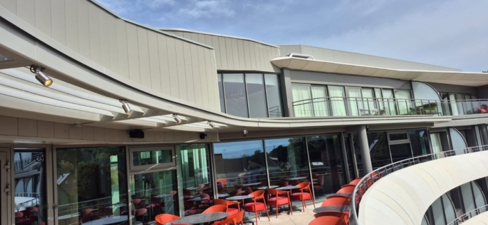 Fabrication et pose d’un brise-soleil sur mesure à l’Hôtel Royal Palace de Kirrwiller Vue d'ensemble du brise-soleil courbe sur la façade vitrée du restaurant panoramique