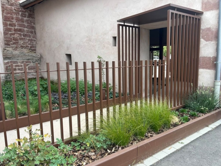 Garde-corps barreaudé, clôture et casquette façon claustra devant une entrée